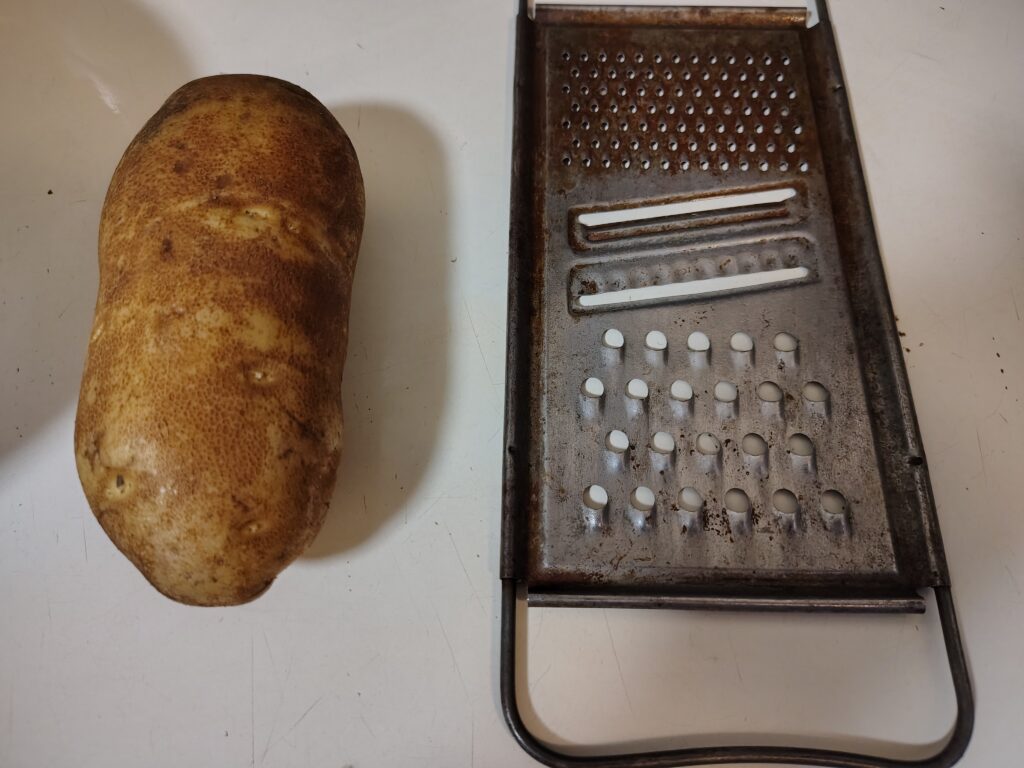 A russet potato and grater.