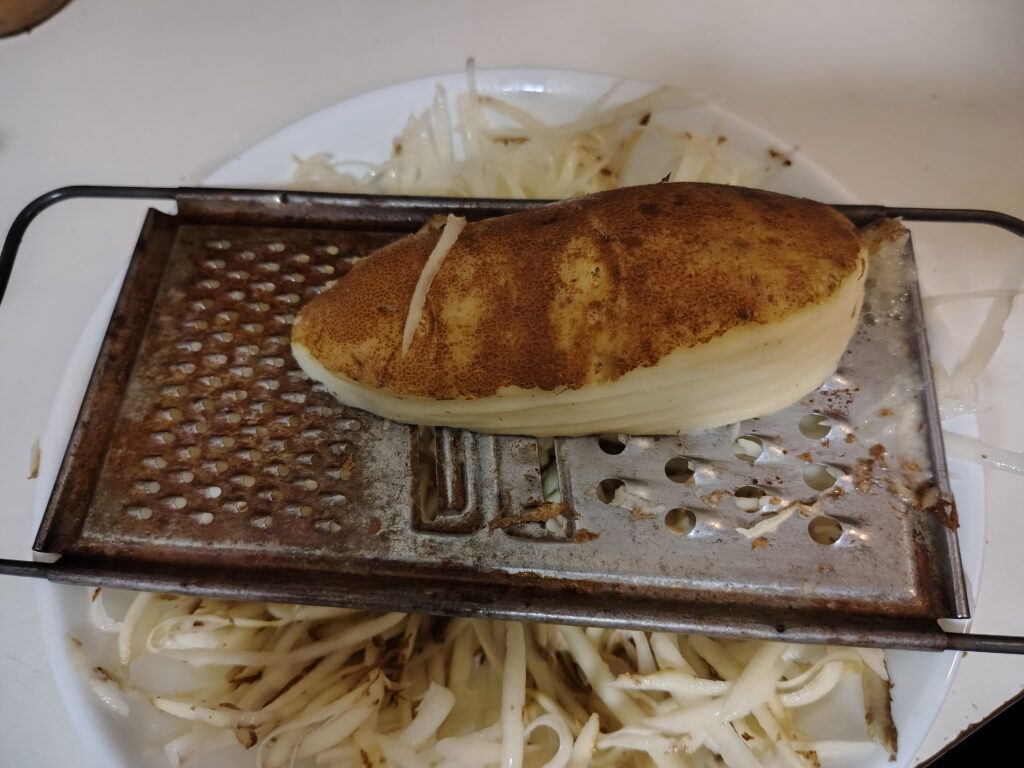 Grating along the long axis of the potato.