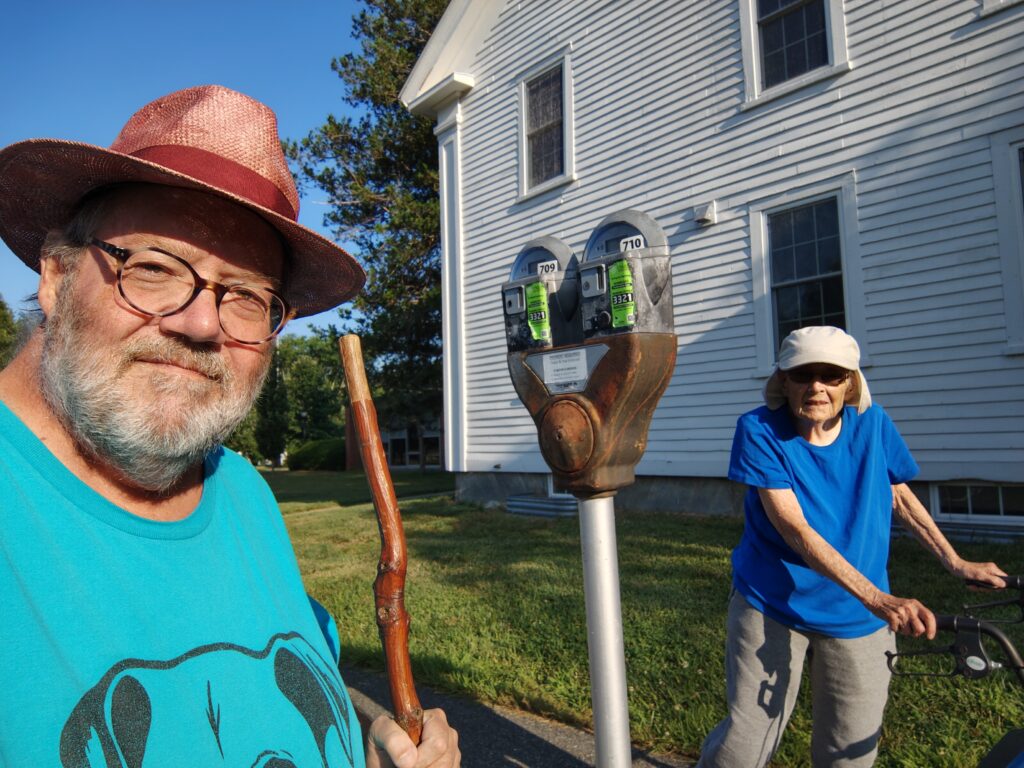 a man and older woman separated by a parking meter